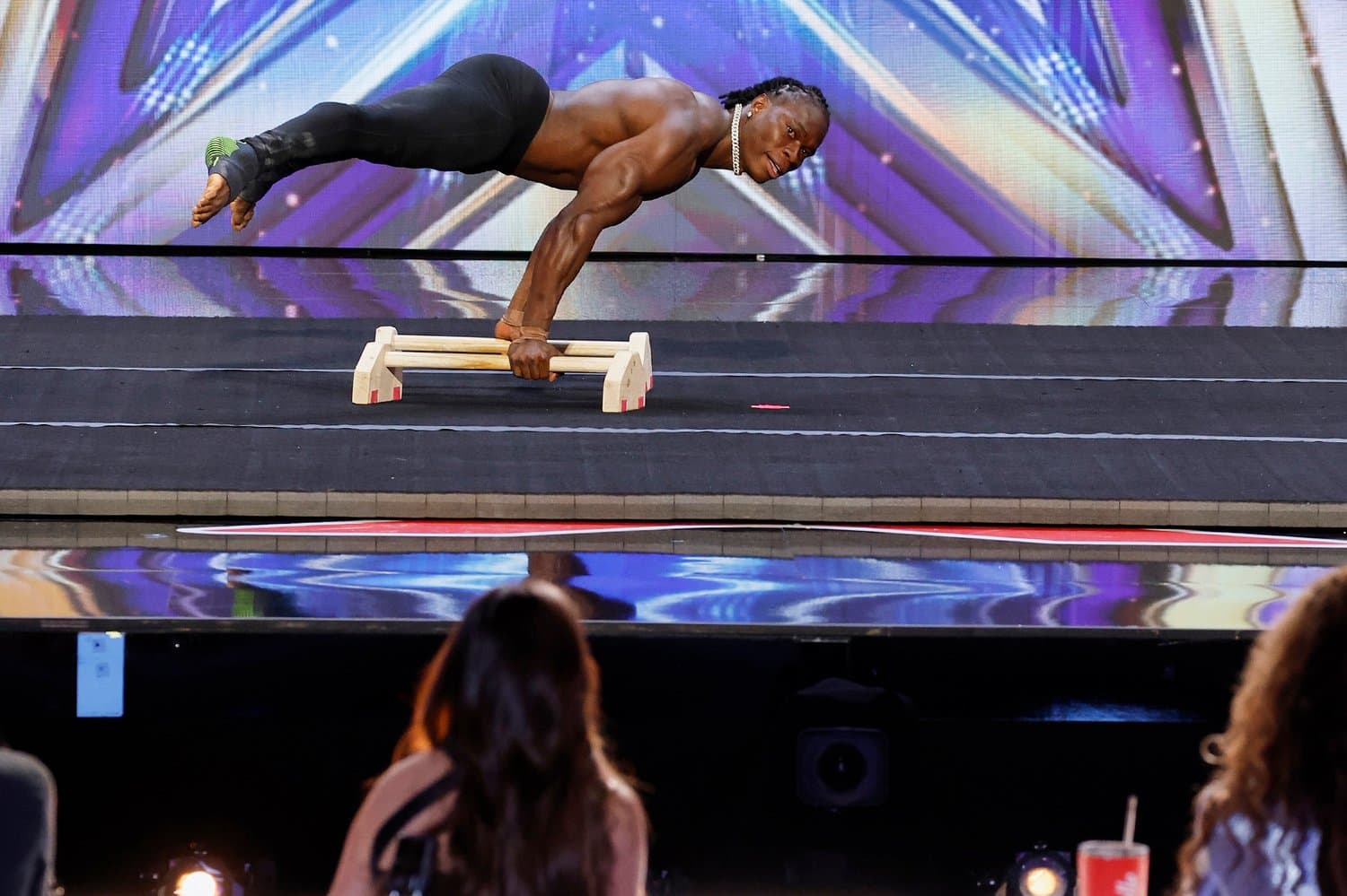 Beast Nation performer suspended mid-routine under a spotlight